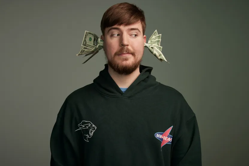Mr. Beast stands with money coming out of his ears