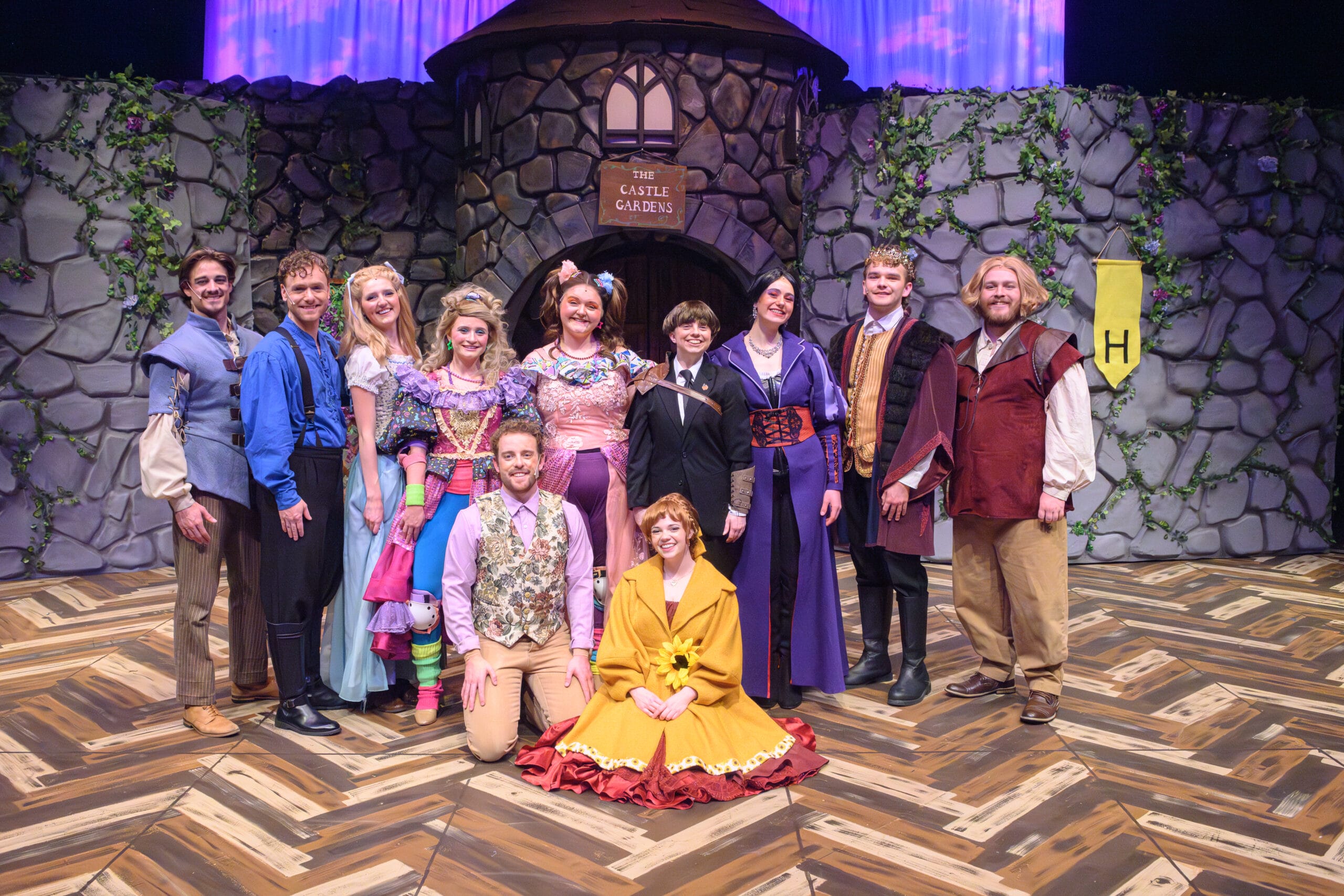 The cast of "The Whole Story" poses in front of the 'castle gardens' set
